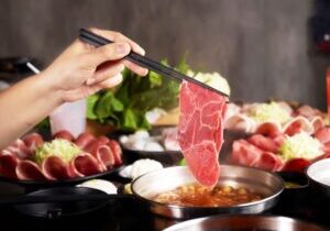 Hand,Holding,Chopsticks,Dipping,Raw,Meat,Slice,Into,Hotpot